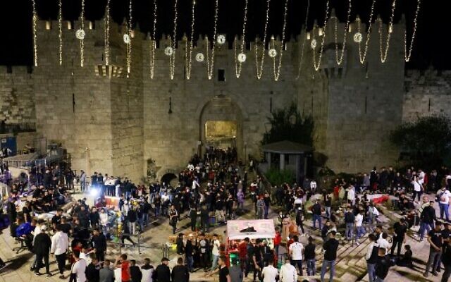 Les Palestiniens se réunissent aux abords de la porte de Damas, dans la Vieille Ville de Jérusalem, au premier soir du Ramadan, le 2 avril 2022. (Crédit :  Menahem KAHANA / AFP)