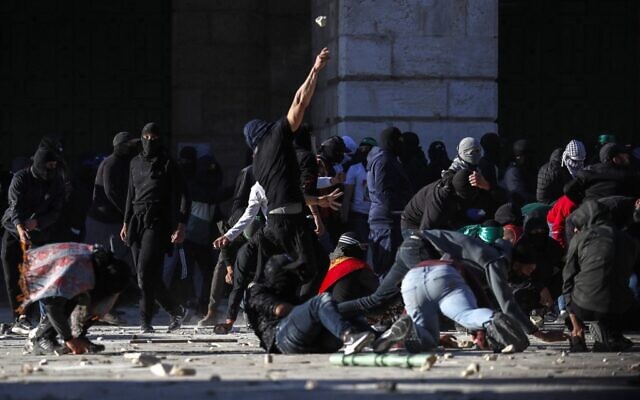 Des Palestiniens affrontent les forces de sécurité israéliennes sur le mont du Temple dans la vieille ville de Jérusalem, le 15 avril 2022. (Crédit: Ahmad Gharabli/AFP)