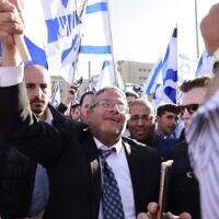 Le député Itamar Ben Gvir, chef de la faction d'extrême-droite Otzma Yehudit, hissant un drapeau israélien sur la place Safra, à Jérusalem, le 20 avril 2022. (Crédit : Menahem Kahana/AFP)