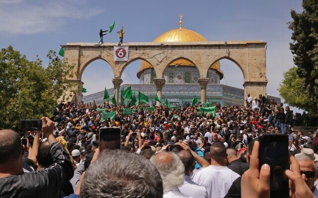 Les Palestiniens scandent des slogans et brandissent des drapeaux du Hamas après les prières du vendredi pendant le mois sacré du ramadan musulman, sur le mont du Temple, dans la Vieille Ville de Jérusalem, le 22 avril 2022. (Crédit : AHMAD GHARABLI / AFP)