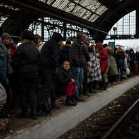 Des passagers attendent sur le quai de la gare de Lviv, dans l'ouest de l'Ukraine, le 27 février 2022. (Crédit : Bernat Armangue /AP)