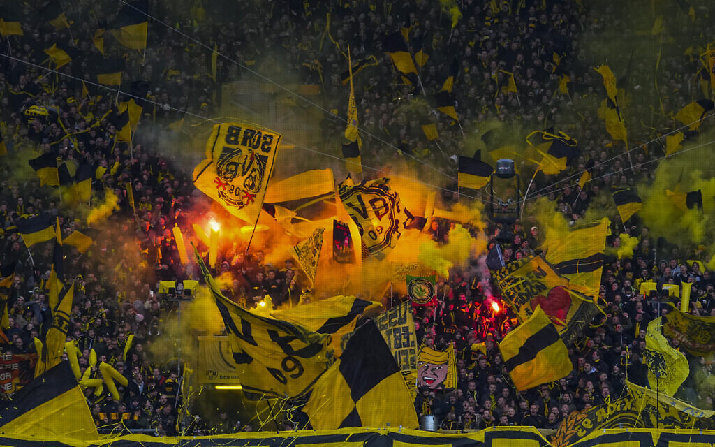 Les supporters de Dortmund allument des fusées de détresse au début du match de football de la Bundesliga allemande entre le Borussia Dortmund et le RB Leipzig à Dortmund, en Allemagne, le 2 avril 2022. (Crédit : Martin Meissner/AP)
