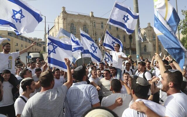 Des Israéliens brandissent des drapeaux lors d’une marche célébrant la Journée de Jérusalem, à Jérusalem, le 10 mai 2021. (Crédit : AP Photo/Ariel Schalit)