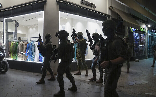 Les forces de l'ordre israéliennes recherchent des assaillants près des lieux d’un attentat terroriste à Tel-Aviv, Israël, le 7 avril 2022. (Crédit : AP Photo/Ariel Schalit)