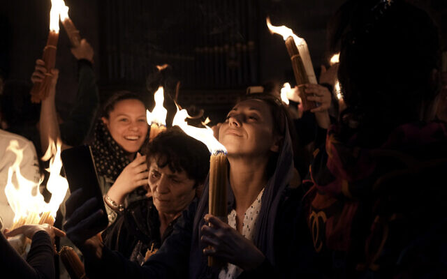 Des pèlerins chrétiens tiennent des bougies alors qu'ils se rassemblent pendant la cérémonie du feu sacré à l'église du Saint-Sépulcre, dans la Vieille Ville de Jérusalem, samedi 23 avril 2022. (Crédit : AP Photo/Maya Alleruzzo)