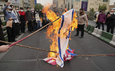 Des manifestants brûlent des représentations de drapeaux israélien, britannique et américain lors du rassemblement annuel pro-palestinien de la Journée d'Al-Quds, à Téhéran, en Iran, le vendredi 29 avril 2022. (Crédit : AP Photo/Vahid Salemi)