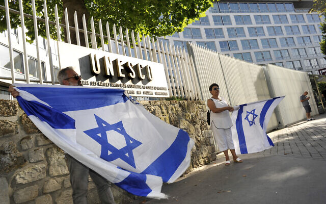 Des Juifs français tiennent des drapeaux israéliens, alors qu'ils participent à une manifestation contre l'UNESCO, près du siège parisien de l'agence culturelle, le 17 juillet 2017. (Crédit : Serge Attal/Flash90)