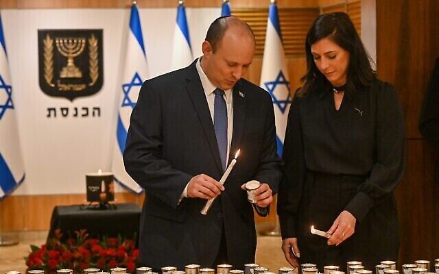 Le Premier ministre Naftali Bennett et son épouse, Gilat, allument des bougies pour la cérémonie 'À chaque personne, un nom' à la Knesset, le 28 avril 2022. (Crédit : Koby Gideon/GPO)