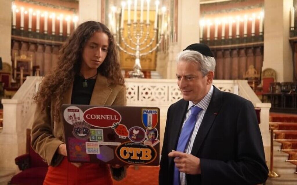 Lior Cole montre son projet d’intelligence artificielle Robo Rabbi au Rabbin Moshe Lewin à la Grande Synagogue de Paris. (Crédit : Avec l’aimable autorisation de la BBC)