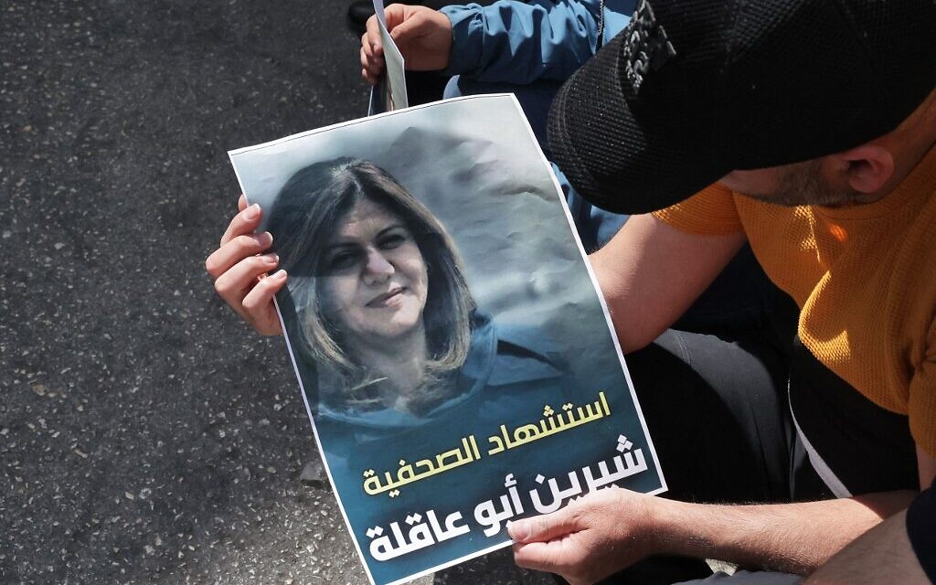 Des Palestiniens tiennent une photto de la journaliste d'Al Jazeera Shireen Abu Aqleh, abattue lors d'affrontements entre soldats israéliens et Palestiniens dans le camp de réfugiés de Jénine en Cisjordanie, le 11 mai 2022. (Crédit : HAZEM BADER / AFP)