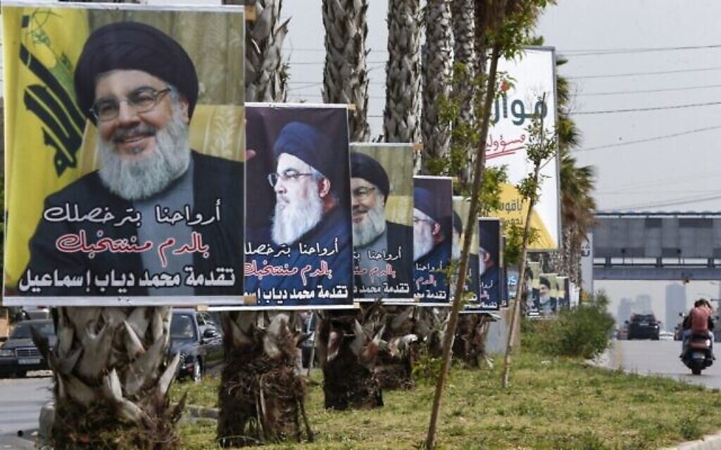 Des affiches exprimant le soutien au chef du Hezbollah libanais Hassan Nasrallah sont accrochées sur une route principale de la capitale Beyrouth, le 14 mai 2022, à la veille des élections législatives. (Crédit : LOUAI BESHARA / AFP)
