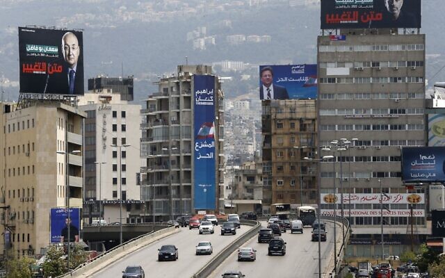 Des panneaux électoraux surplombent un pont à Beyrouth, la capitale du Liban, le 14 mai 2022, à la veille des élections législatives. (Crédit : LOUAI BESHARA / AFP)