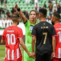L'arbitre marocaine Bouchra Karboubi fait des gestes aux joueurs pendant le match entre le club AS FAR (Association sportive des Forces armées royales marocaines) et le Moghreb Atletico Tetouan à Agadir le 14 mai 2022. (Crédit : AFP)