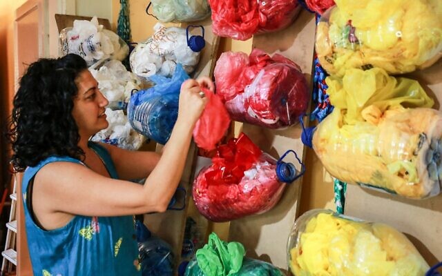 Maria Nissan, artiste et activiste environnementale, trie des sacs utilisés pour créer des installations artistiques à partir de déchets plastiques collectés dans les rues, dans la capitale jordanienne Amman, le 17 mai 2022. (Crédit : Khalil MAZRAAWI / AFP)