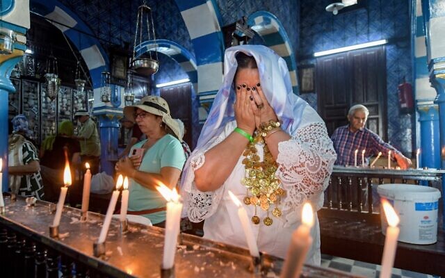 Des pèlerins juifs prient à la synagogue de la Ghriba sur l'île de Djerba, dans le sud de la Tunisie, le 18 mai 2022, lors du pèlerinage juif annuel à la synagogue. (Crédit : FETHI BELAID / AFP)