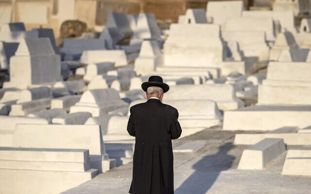 Un membre de la communauté juive devant des tombes lors d’un pèlerinage dans un cimetière juif de la ville de Meknès, dans le nord du Maroc, le 18 mai 2022. (Crédit : FADEL SÉNÉ / AFP)