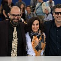 L’acteur arabo-israélien Amer Hlehel, le réalisateur arabo-israélien Maha Haj et l’acteur arabo-israélien Ashraf Farah se livrent à une séance de photo pour le film "Fièvre méditerranéenne" lors de la 75e édition du Festival de Cannes, dans le sud de la France, le 25 mai 2022. (Crédit : Patricia De Melo Moreira/AFP)