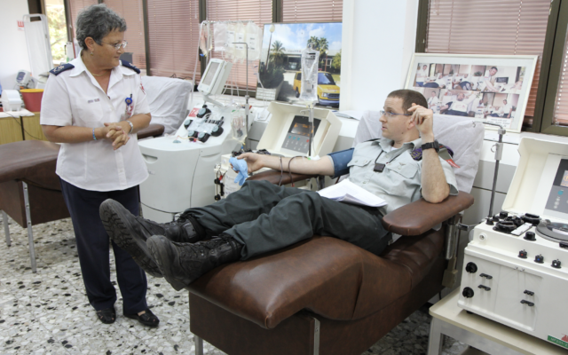 Le professeur Eilat Shinar, directeur des services sanguins du Magen David Adom, reçoit un don d'un Israélien. (Crédit : Autorisation Magen David Adom)