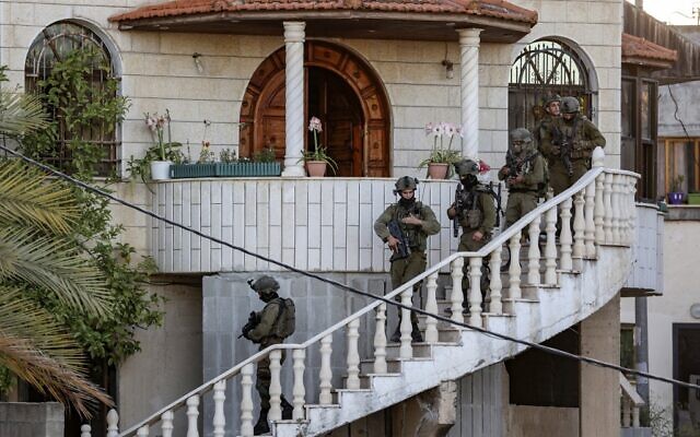 Des soldats israéliens effectuent un raid au domicile d'un terroriste palestinien accusé d'avoir commis une attaque à la hache dans la ville centrale d'Elad deux jours auparavant dans la ville de Rummanah, près de la ville de Jenin, en Cisjordanie, le 8 mai 2022. (Crédit : JAAFAR ASHTIYEH/AFP)