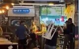Des personnes se battent en se jetant des chaises et des tables, au marché Mahane Yehuda de Jérusalem le 15 mai 2022. (Crédit : capture d'écran)