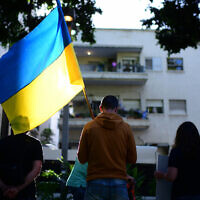 Des manifestants portent des pancartes et des drapeaux ukrainiens lors d'une manifestation contre l'invasion de l'Ukraine par la Russie, sur le boulevard Rothschild à Tel Aviv, le 8 mai 2022. (Crédit : Tomer Neuberg/Flash90)