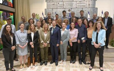 Le président Isaac Herzog et son épouse Michal (à sa droite) posent avec les membres du President's Climate Forum sur le climat, à la résidence du président à Jérusalem, le 17 mai 2022. Dov Khenin est troisième à partir de la droite, tandis que Zohar Berman est deuxième à partir de la gauche. (Crédit : Amos Ben-Gershom/GPO)