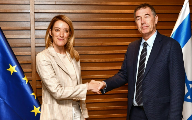 La présidente du Parlement européen Roberta Metsola (à gauche) serre la main du député Yisrael Beytenu Yossi Shain après son arrivée en Israël le 22 mai 2022. (Crédit : Autorisation)