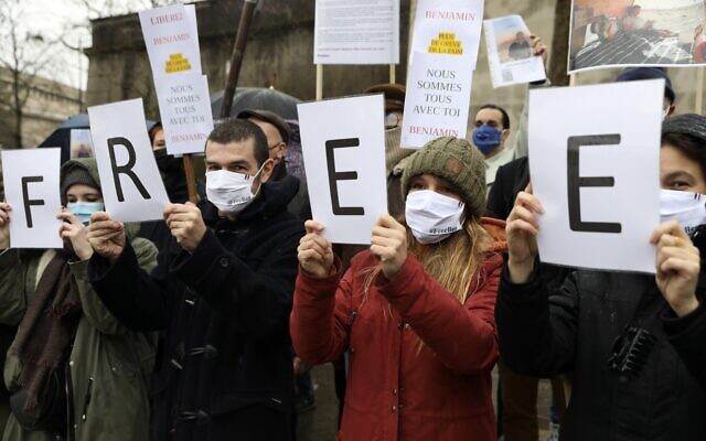 Des personnes tiennent des pancartes lors d'un rassemblement à Paris pour le citoyen français Benjamin Briere, un touriste emprisonné en Iran depuis près de deux ans, le 8 janvier 2022. (Crédit : AP Photo/Adrienne Surprenant)
