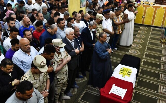 Des hommes prient devant le cercueil du soldat Ahmed Mohamed Ahmed Ali, tué au combat, lors de ses funérailles, dans la province de Qalyubia, en Egypte, le 8 mai 2022. Au moins 11 soldats égyptiens, dont un officier, ont été tués le 7 mai 2022 dans une attaque militante contre une station de pompage d'eau à l'est du canal de Suez, a déclaré l'armée. (Crédit : AP Photo/Sayed Hassan)