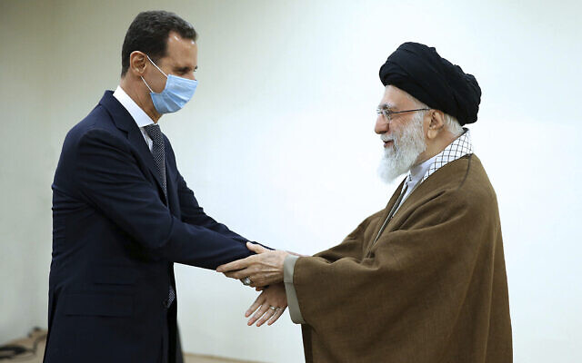 Sur cette photo publiée par le site officiel du bureau du guide suprême iranien, le guide suprême, l'ayatollah Ali Khamenei, à droite, et le président syrien Bashar Assad se serrent la main au début de leur rencontre, à Téhéran, en Iran, le 8 mai 2022. (Crédit : Bureau du Guide suprême iranien via AP)