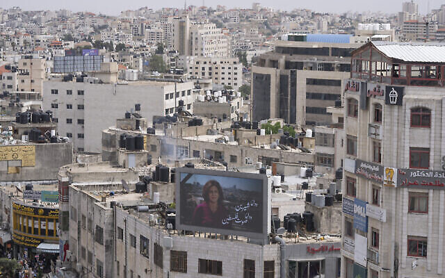 Un écran géant diffuse une photo de la journaliste d’Al Jazeera, Shireen Abu Akleh, avec un texte arabe qui signifie : « Au revoir Shireen, la voix de la Palestine », au centre de la ville de Ramallah en Cisjordanie, le mercredi 11 mai 2022, quelques heures après sa mort à Jénine. (Crédit : AP Photo/Nasser Nasser)