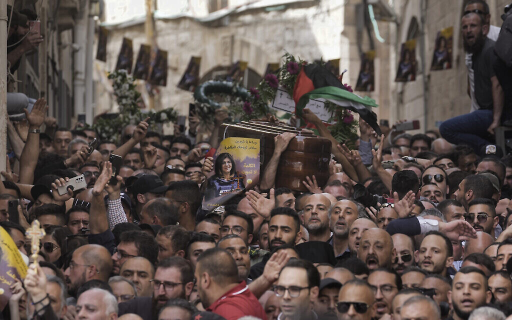 Une foule endeuillée accompagne le cercueil de la journaliste d’Al Jazeera, Shireen Abu Akleh, lors de ses funérailles dans la Vieille Ville de Jérusalem, le 13 mai 2022. (Crédit : AP Photo/Mahmoud Illean)