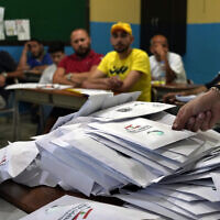 Des agents électoraux comptent les bulletins de vote peu après la fermeture des bureaux de vote, dans la ville de Tripoli, au nord du Liban, le 15 mai 2022. (Crédit : AP Photo/Bilal Hussein)