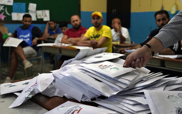 Des agents électoraux comptent les bulletins de vote peu après la fermeture des bureaux de vote, dans la ville de Tripoli, au nord du Liban, le 15 mai 2022. (Crédit : AP Photo/Bilal Hussein)