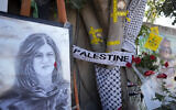 Du ruban jaune marque les impacts de balles sur un arbre et un portrait et des fleurs forment un mémorial de fortune sur le site où la journaliste palestino-américaine d'Al-Jazeera Shireen Abu Akleh a été tuée par balle dans la ville de Jénine, en Cisjordanie, le jeudi 19 mai 2022. (Crédit : AP/Majdi Mohammed)