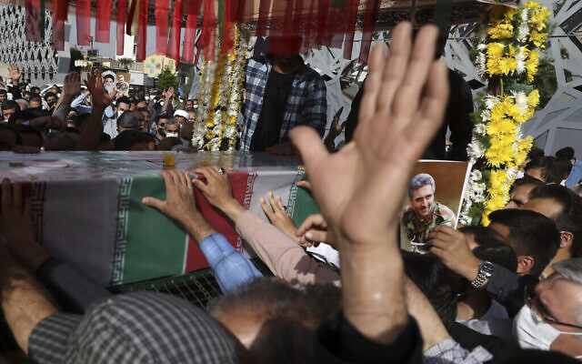 Des personnes pleurent aux côtés du cercueil drapé du colonel des Gardiens de la révolution iranienne, Hassan Sayyad Khodaei, tué dimanche, lors de sa cérémonie funèbre à Téhéran, en Iran, le mardi 24 mai 2022. (Crédit : AP/Vahid Salemi)