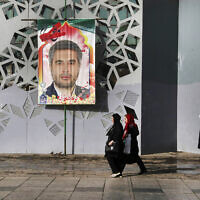 Des personnes passent devant une bannière montrant le colonel Hassan Sayyad Khodaei des Gardiens de la révolution iraniens, tué dimanche, avant la cérémonie de ses funérailles, à Téhéran, en Iran, le 24 mai 2022. (Crédit : AP Photo/Vahid Salemi)