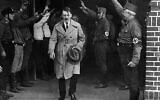 Dans cette photo du 5 décembre 1931, Adolf Hitler, chef des nationaux-socialistes, est salué alors qu’il quitte le siège du parti à Munich (Crédit : AP Photo, Archive)