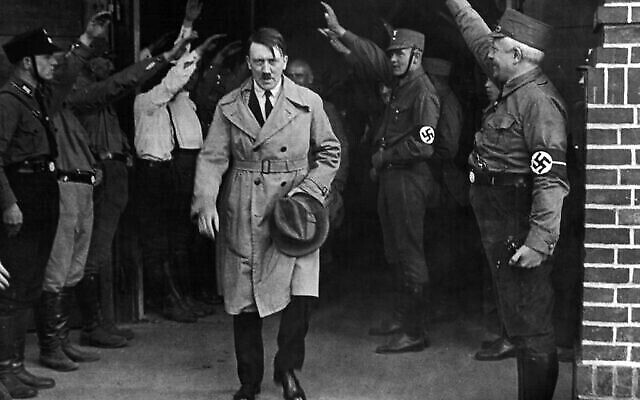 Dans cette photo du 5 décembre 1931, Adolf Hitler, chef des nationaux-socialistes, est salué alors qu’il quitte le siège du parti à Munich (Crédit : AP Photo, Archive)