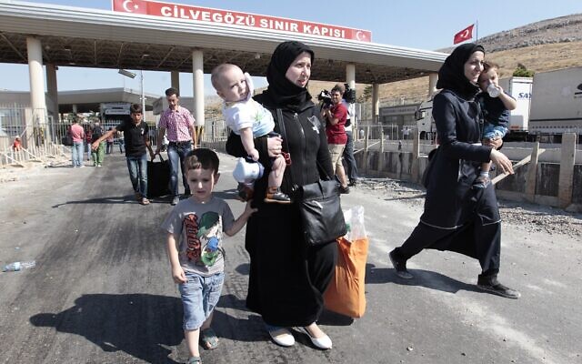 Des réfugiés syriens traversent la frontière turque de la porte de Cilvegozu, le 31 août 2013, au plus fort de la guerre civile syrienne. (Crédit : AP Photo/Gregorio Borgia)