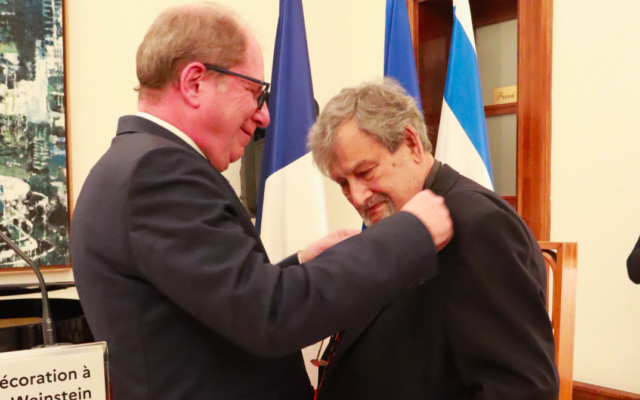 Eric Danon, ambassadeur de France en Israël, remet les insignes de Chevalier de la Légion d’Honneur au luthier israélien Amnon Weinstein, à l’ambassade de France en Israël, à Tel Aviv, le 17 mars 2022. (Crédit : Ambassade de France en Israël)