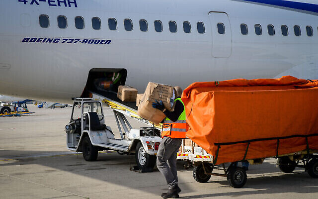 Des ouvriers chargent des paquets d'aide humanitaire israélienne pour l'Ukraine sur des avions d'El Al, à l'aéroport Ben Gourion de Tel Aviv, le 1er mars 2022. (Crédit: Avshalom Sassoni/Flash90)