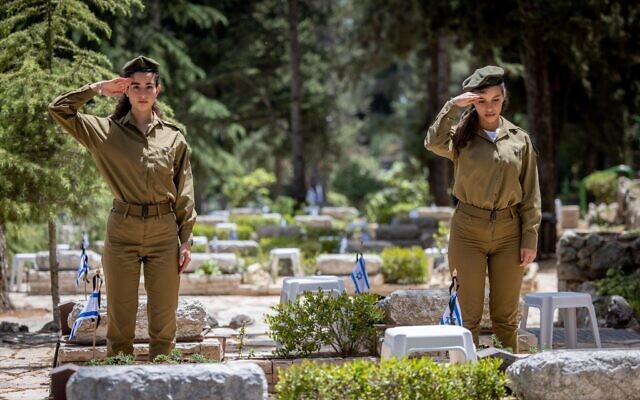 Des soldats israéliens devant les tombes de soldats morts au combat au cimetière militaire du Mont Herzl à Jérusalem, le 2 mai 2022. (Crédit : Yonatan Sindel/Flash90)
