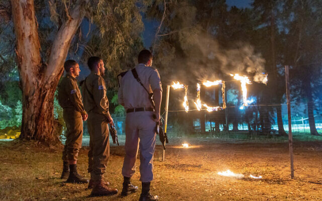 Une cérémonie marquant Yom HaZikaron en hommage aux soldats israéliens tombés au combat et des victimes du terrorisme, au Moshav Yashresh, le 3 mai 2022. Le panneau indique "Yizkor" ou "in memoriam". (YCrédit : Yossi Aloni/Flash90)