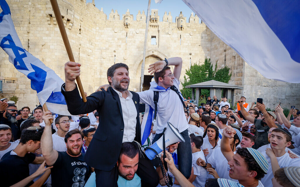Le chef du parti Sionisme religieux Bezalel Smotrich brandit le drapeau israélien à la porte de Damas, dans la Vieille Ville de Jérusalem, lors de Yom Yeroushalayim, le 29 mai 2022. (Crédit :  Olivier Fitoussi/Flash90)