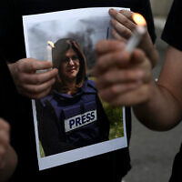 Des manifestants tiennent des bougies et une photo de la journaliste d'Al Jazeera tuée à Jénine, Shireen Abu Akleh, à Haïfa, en Israël, le 11 mai 2022. (Crédit : AP Photo/Ariel Schalit)