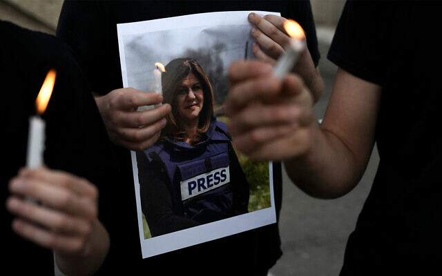 Des manifestants tiennent des bougies et une photo de la journaliste d'Al Jazeera tuée à Jénine, Shireen Abu Akleh, à Haïfa, en Israël, le 11 mai 2022. (Crédit : AP Photo/Ariel Schalit)