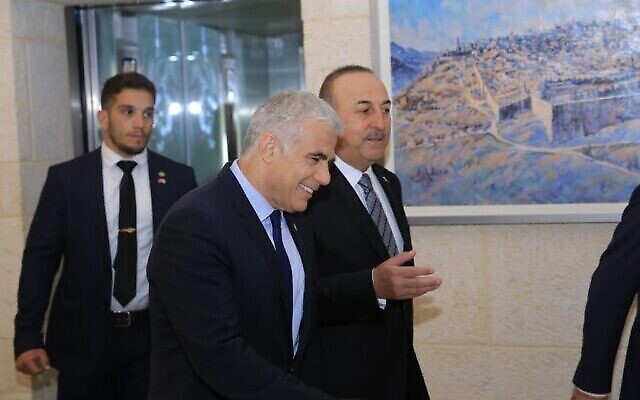 Le ministre des Affaires étrangères Yair Lapid, au centre, s'entretient avec son homologue turc Mevlut Cavusoglu au ministère des Affaires étrangères à Jérusalem, le 25 mai 2022. (Crédit: Asi Efrati/GPO)
