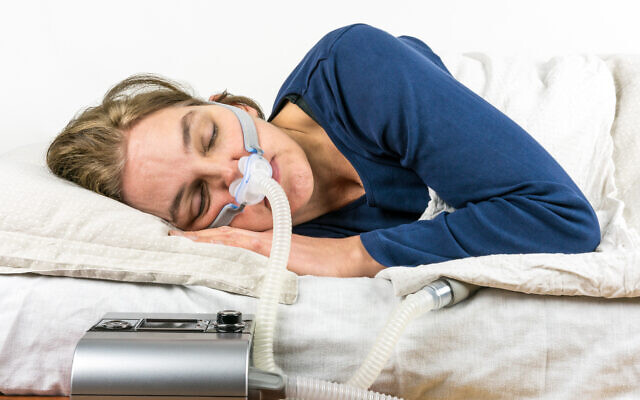 Illustration : une femme reçoit de l’oxygène pendant son sommeil, en traitement de l’apnée du sommeil. (Crédit : Perboge via iStock par Getty Images)