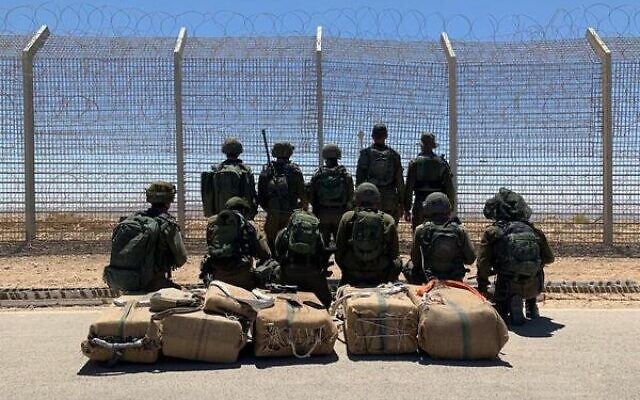 Les soldats à côté de drogues saisies pendant une tentative de trafic sur la frontière égyptienne, le 25 mai 2022. (Crédit : Armée israélienne)
